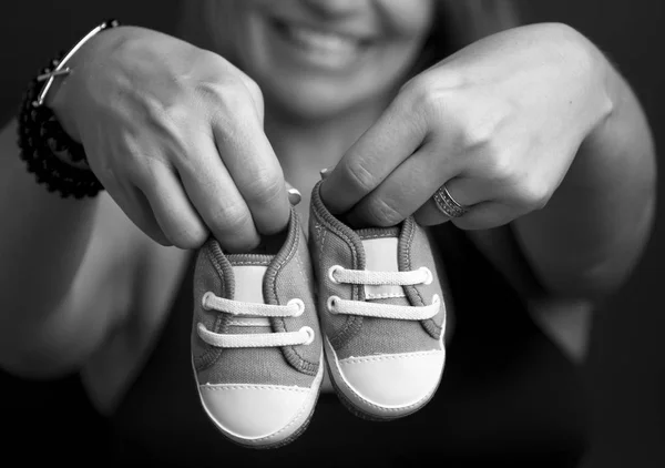 Yenidoğan için ayakkabı holding hamile eller 