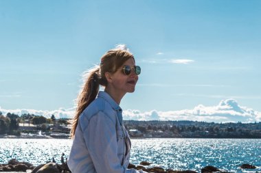 Vancouver, Kanada Kitsilano Plajı'nda bir kayaya oturan kız