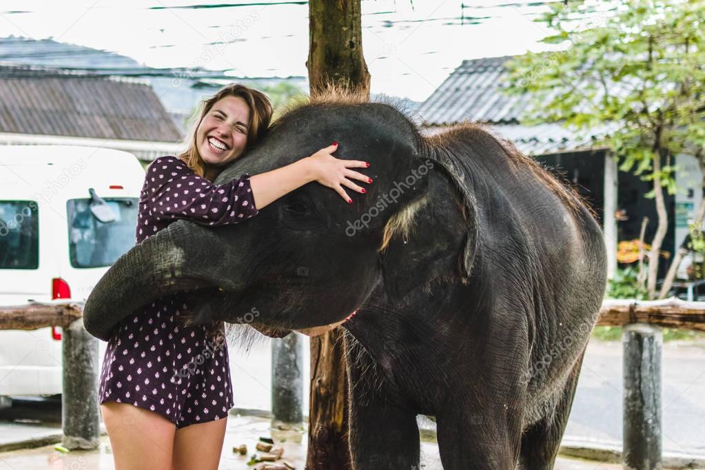 Girl Feeding Baby Elephant in Thailand