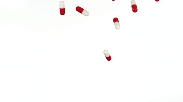 Capsules rouges et blanches tombant — Video