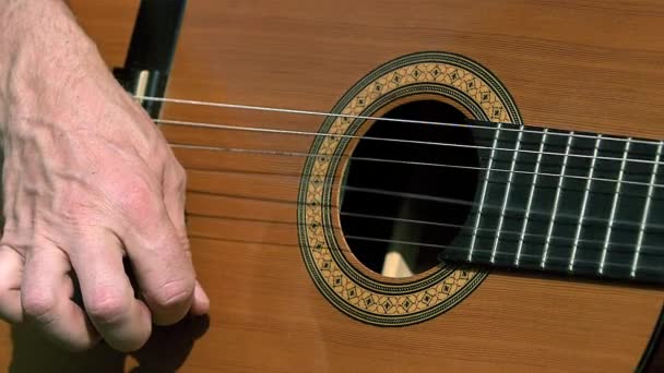 Человек играет на акустической гитаре — стоковое видео