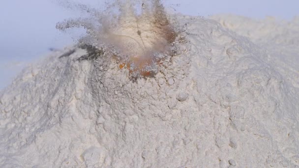 Uovo che cade nella farina sullo sfondo bianco, rallentatore — Video Stock