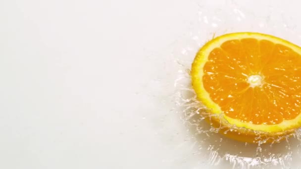 Orange Slice Falling on Water and splashing — Stock Video