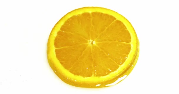 Капля воды падает на апельсиновый ломтик — стоковое видео