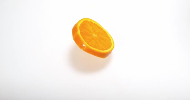 Orangenscheibe fällt auf Wasser und spritzt — Stockvideo