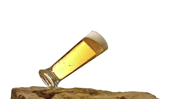 Ποτήρι της μπύρας πτώση, σπάσιμο και πιτσίλισμα στο πέτρινο φόντο λευκό, αργή κίνηση — Αρχείο Βίντεο