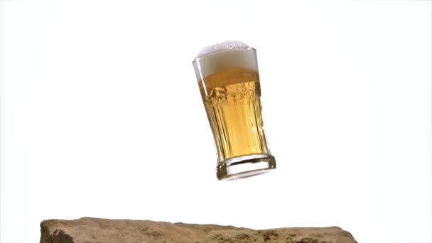 ガラスのビールは落下し、白い背景に、スローモーションの石はね — ストック動画