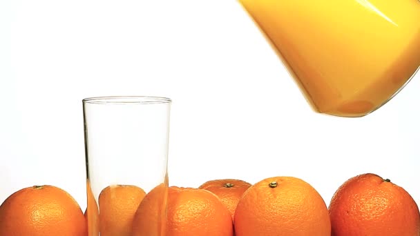 Апельсиновый сок наливают в стекло — стоковое видео
