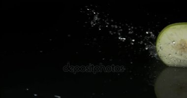 Granny Smith elma, malus domestica, dilim su siyah arka plan, yavaş hareket karşı açma