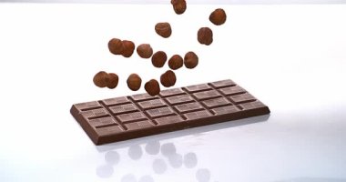 Sütlü çikolata tablet üzerinde düşen fındık
