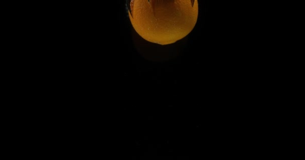 Narancs, citrus sinensis, gyümölcs alá a vízbe, fekete háttér, lassú mozgás, 4k
