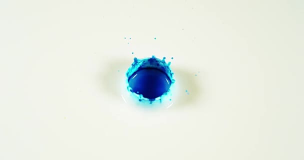 Liquide bleu tombant dans l'eau 