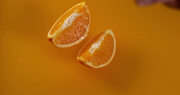 Fruta de laranja caindo no suco de laranja — Vídeo de Stock
