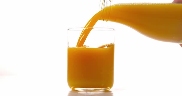 Апельсиновый сок наливают в стекло — стоковое видео
