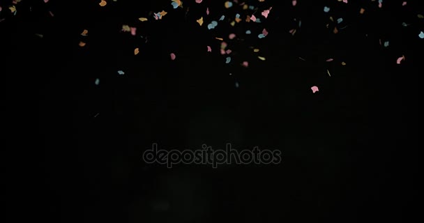 Confettis tombant contre le noir 