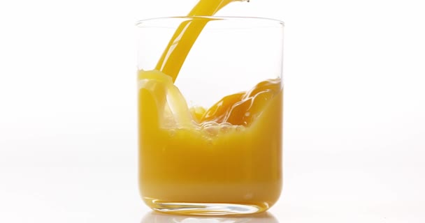 Orangensaft wird ins Glas gegossen — Stockvideo