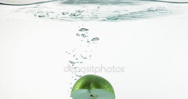 Granny Smith elma, malus domestica, beyaz arka plan, yavaş hareket 4 k girerek su meyve