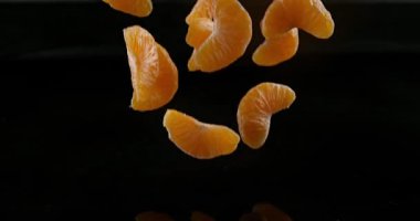 Clementines, narenciye reticulata, su siyah arka plan, yavaş hareket 4 k karşı düşen meyve