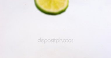 Yeşil limon su üzerinde düşen 