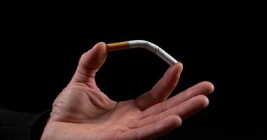 Siyah arka plan, yavaş hareket 4 k üzerinde bir sigara tatili adamın elini