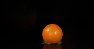 Orange, citrus sinensis, meyve düşen su siyah arka plan, yavaş hareket 4k