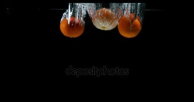 Clementines, narenciye reticulata, siyah arka plan, yavaş hareket 4 k suya düşen meyve