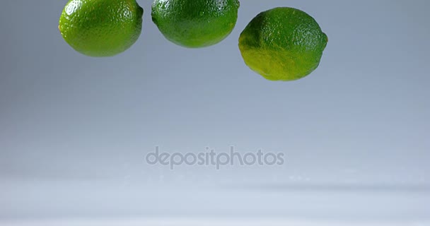 Limes verdes caindo na água — Vídeo de Stock