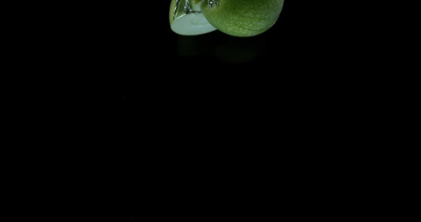 Avó Smith maçãs, malus domestica, frutas que entram na água contra fundo preto, câmera lenta 4K — Vídeo de Stock