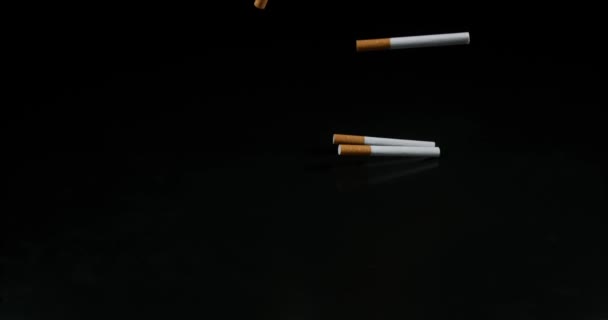 Sigaretten vallen tegen zwarte achtergrond, Slowmotion 4k — Stockvideo