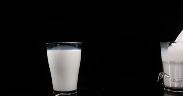 Glas van melk splatching tegen witte achtergrond, Slowmotion 4k — Stockvideo