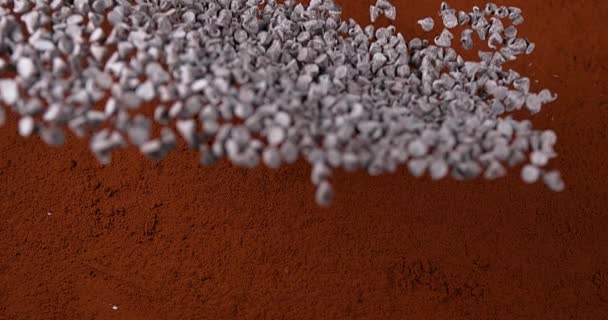 Pimentas de Chocolate Caindo em Pó de Chocolate — Vídeo de Stock