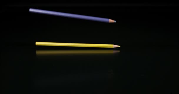 Lápis de cor caindo contra fundo preto, câmera lenta 4K — Vídeo de Stock