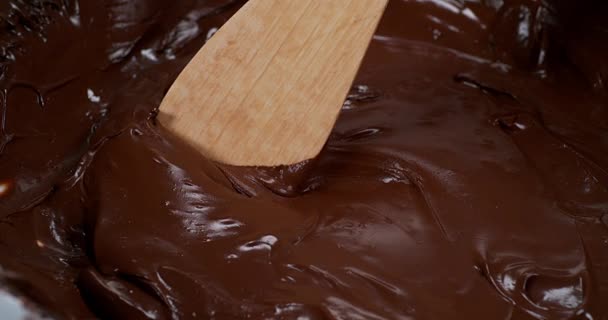 Деревянная ложка, превращающая молочный шоколад — стоковое видео