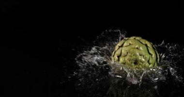 Enginar, Cynara scolymus, Sebzeler Kara Arkaplanda Suya Düşüyor, Ağır çekim 4k