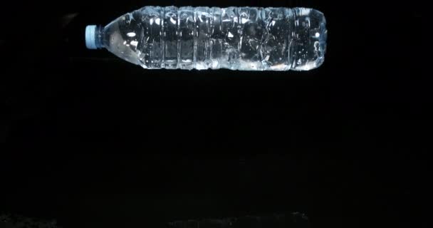 Wasserflasche Fällt Auf Wasser Vor Schwarzem Hintergrund Zeitlupe — Stockvideo