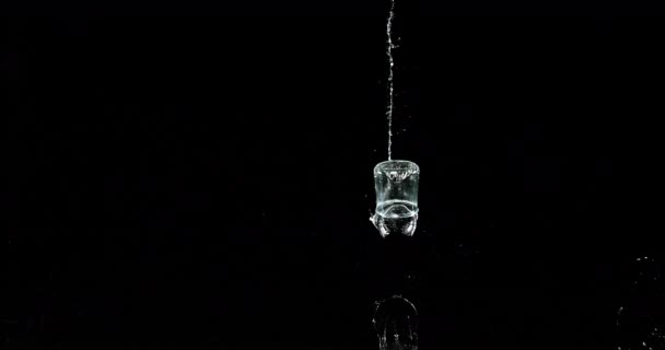Ποτήρι Νερού Πηδώντας Και Πιτσιλίζοντας Μαύρο Φόντο Αργή Κίνηση — Αρχείο Βίντεο