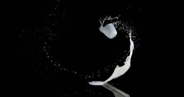Verre de lait rebondissant et éclaboussant sur fond noir, mouvement lent 4K 