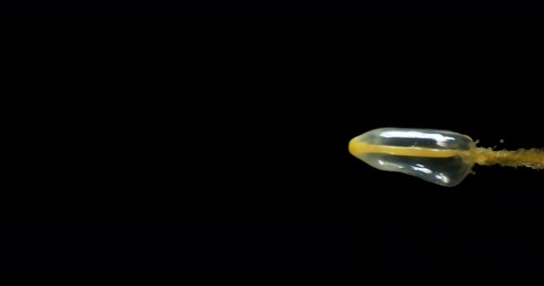 Jus d'orange explosant et éclaboussant sur fond noir, mouvement lent 4K 