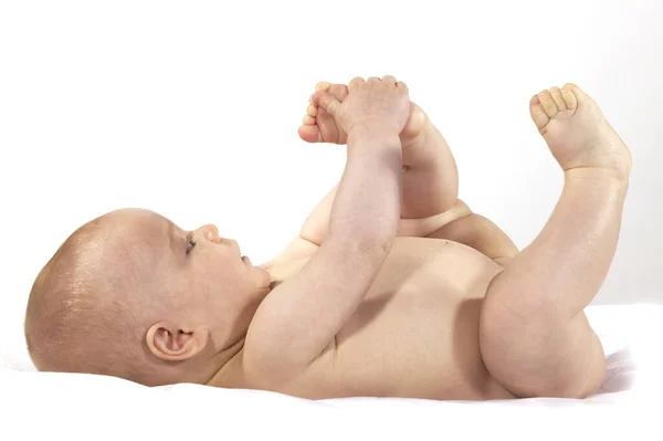 Baby Boy Ayağıyla Beyaz Arkaplan Karşı Oynuyor — Stok fotoğraf