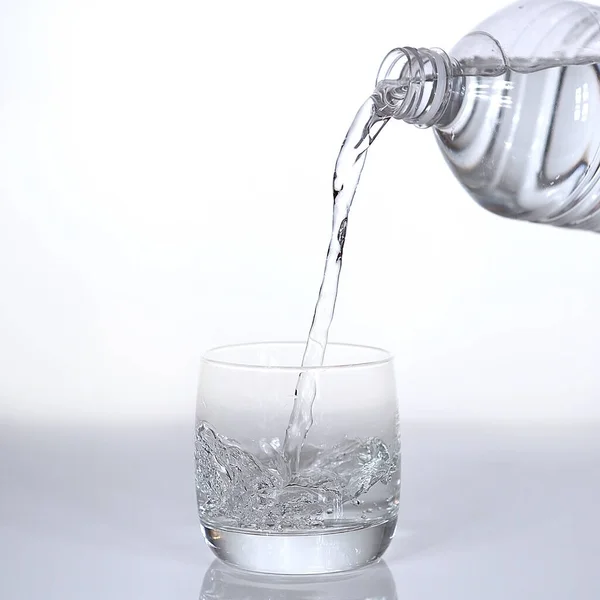 Agua Que Vierte Vidrio Contra Fondo Blanco —  Fotos de Stock