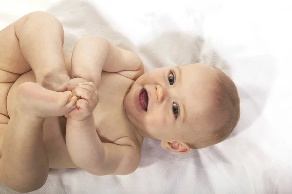 Baby Boy Leikkii Hänen Jalka Vastaan Valkoinen Tausta — kuvapankkivalokuva