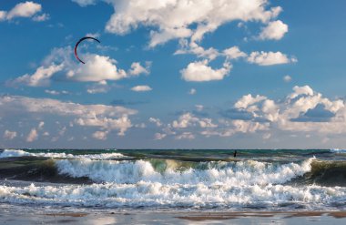 Onun uçurtma ile fırtınalı bir denizin dalgaları sürme Kitesurfer