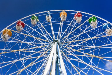 Mavi gökyüzü arka plan üzerinde Renkli kabin ile gözlem tekerleği