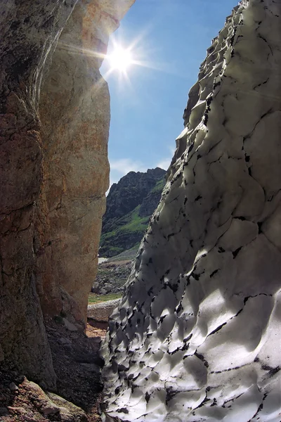 Кливер в Кавказских горах. Фирн оттаивает из скалы, которая нагревается благодаря летнему солнцу — стоковое фото
