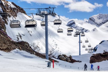 Dağ cirque kayak pisti üzerinde sandalye teleferik Asansör ve mavi gökyüzü kış arka plan karşı güneşli gün ayakta kayakçı