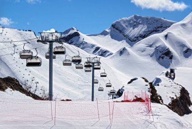 Boş teleferik güneşli kış günü karlı dağ tepe arka plan üzerinde bir boş Kayak Merkezi koltukları Kaldır