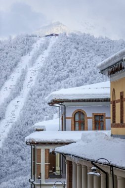 Kar kaplı otel çatılar Gorki Gorod kış dağ tatil beldesinin teleferik ile arka plan dikey sahne üzerinde Asansör