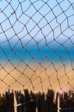 Balık ağı, yaz deniz mavi gökyüzü ve kumlu Plajı manzaralı arka plan. Güzel dikey deniz manzarası