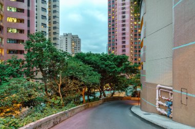 Akşamları Hong Kong 'un yüksek katlı yerleşim bölgesi. Gökdelen binaları ve dar sokakları olan Hong Kong manzaralı bir şehir.