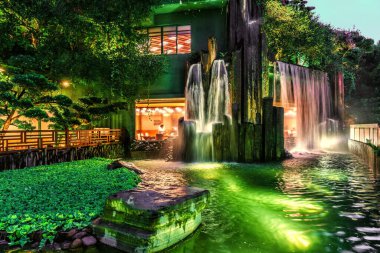 Hong Kong, Çin - 19 Ocak 2016: Hong Kong 'daki Diamond Hill' de Nan Lian Garden 'da şelalesi ve göleti olan bir kafe. Gece manzarası manzarası
